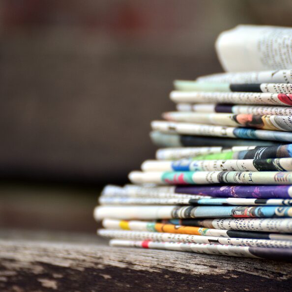 Zeitungen gestapelt auf einem Holztisch